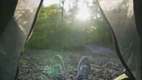 Camp. First-person view from the tent. Forest, sunset, feet in boots Stock Footage 162467353
