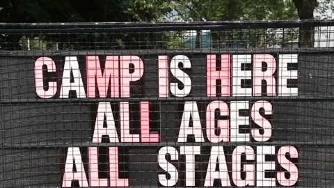 Camp is here all ages all stages sign with trees in background, colorful letters Stock Footage 247143995