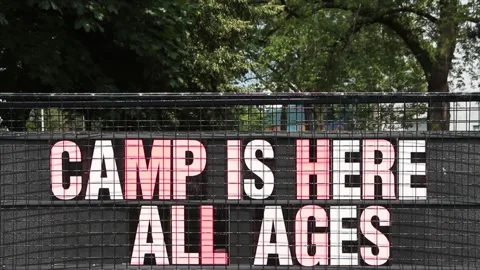 Camp is here all ages sign with trees in background, colorful capital letters Stock Footage 247143992