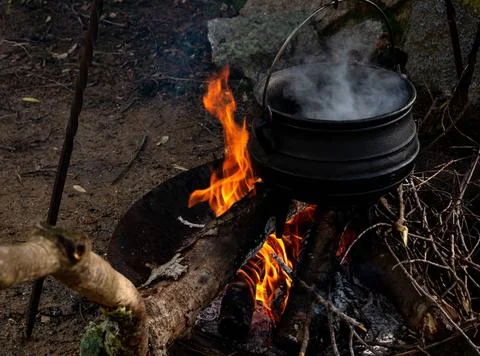 Camp kitchen with cauldron, open steaming hot, metal on fire medieval reen... Stock Photos