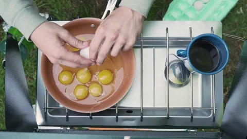 Camp Stove Breakfast Cracking Eggs Into Skillet Stock Footage 285676780