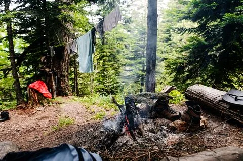 Camp, tourists dry clothes and shoes by the campfire Stock Photos