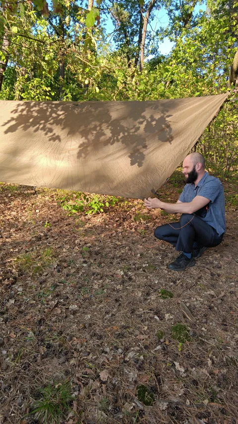 Camper Fastening Tarp Guyline To Ground Stake In Forest Camp Stock Footage 346548698