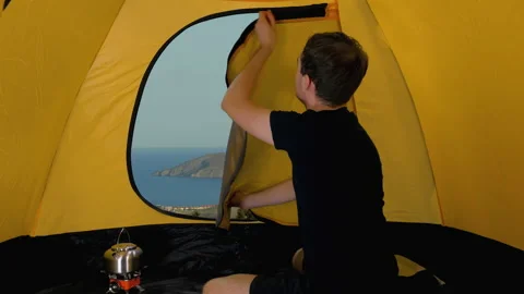 Camper opens tent  and looks out at coastline and bay in Black sea, Crimea Video stock 161019012