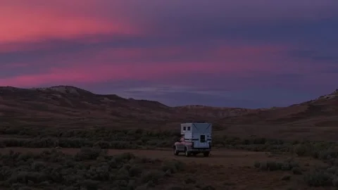 Camper Parked on Sagebrush Plain Beneath Pink Twilight Sky Stock Footage 331557179
