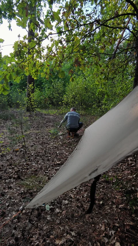 Camper Sitting on Stool and Eating Dinner Near Tarp at Dusk 스톡 동영상 346549318