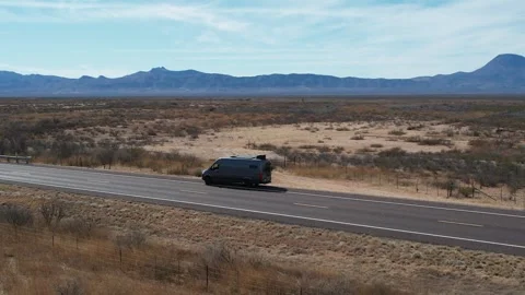 Camper sprinter van drives along lonely desert road in West Texas Stock Footage 276152060