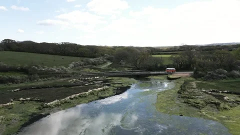 Camper van crosses a small mountain bridge over a babbling river Stock Footage 247054803