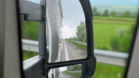 Camper van driving down the highway on a rainy day view from mirror Stock Footage 340626907