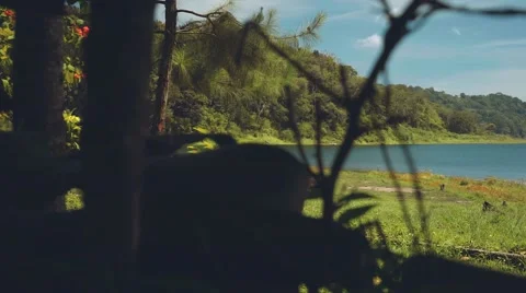 Camper van driving to a lake surrounded by hills Stock Footage 67850776
