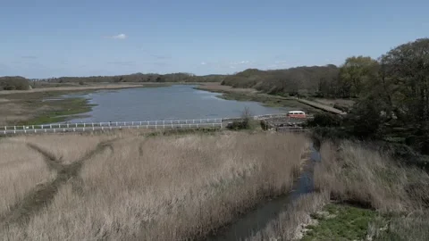 Camper van driving over small English bridge next to a river Stock Footage 247054737