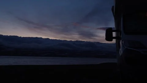 Camper van parked during a beautiful sunset over an icelandic fjord 库存影片 339507204