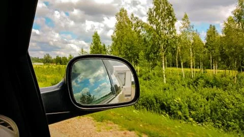 Camper van reflection in the sideview mirror of a car. Stock Photos