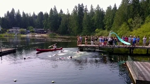 Campers Lining Up, Diving And Swimming In Lake  - panning wide shot Stock Footage 126497199