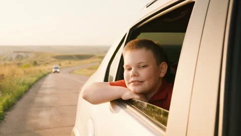 Campervan, car ride back seat, child boy catching wind through window with hand Stock Footage 280346216