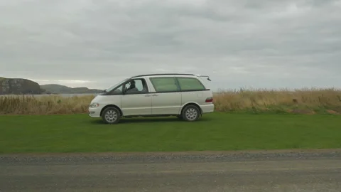 A campervan on the side of a road with the sea behind, in New Zealand Stock Footage 219206904