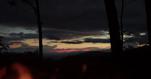 Campfire and Mountain Sunset Framed by Silhouetted Trees Stock-Footage 347241680