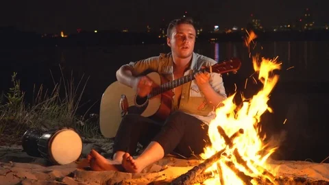 Campfire around the campfire with a guitar Stock Footage 82298587