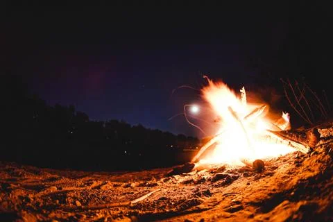 Campfire at the beach in front of the moonlight Stock Photos