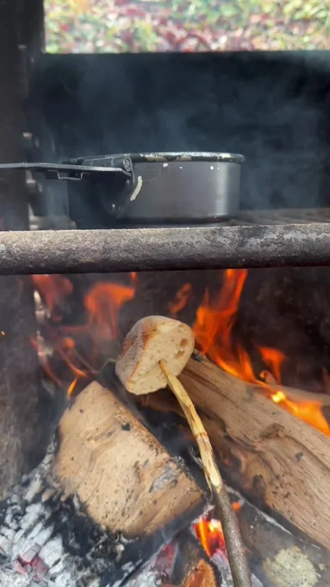 Campfire Bread Toasting with Boiling Tea Kettle in the Forest Stock Footage 296501419
