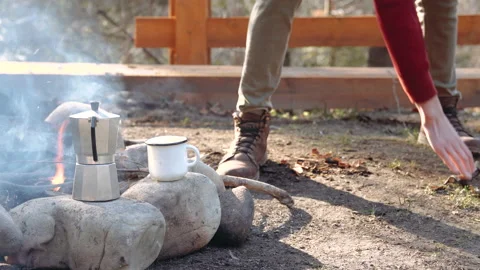 A campfire is burning in the camp. coffee is heated by the fire. Stock Footage 195204571