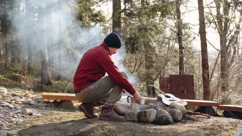 A campfire is burning in the camp. coffee is heated by the fire. Stock Footage 195206129