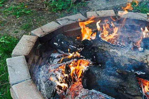 Campfire burning with glowing flames and hot coals outdoors Stock Photos