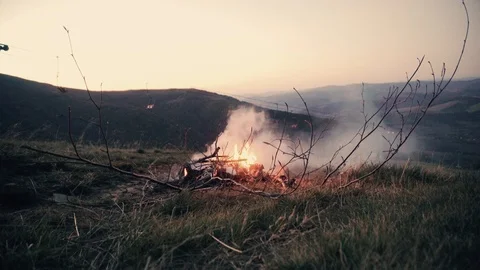 Campfire Burns In Firepit In Field At Sunset, Mountains Stock Footage 98377780