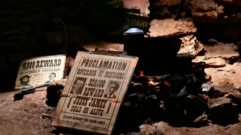 Campfire flickers with wanted posters laying nearby Stock Footage 195237368