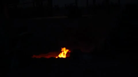 Campfire gathering at dusk with friends in a remote location Video stock 281815758