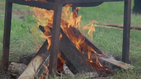 A Campfire is Gently Burning Surrounded by a Sturdy Metal Frame in the Backyard 動画素材 286124013