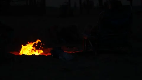 Campfire glowing in the desert night under a starry sky Stock Footage 281819098