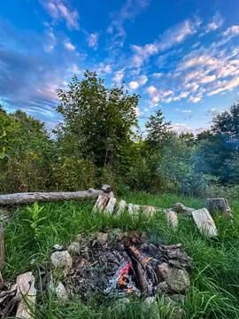 Campfire Glowing at Dusk Under a Dramatic Sky Stock Photos