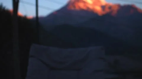 Campfire in the hearth against the backdrop of Mount Kazbegi the morning beams Stock Footage 248530703