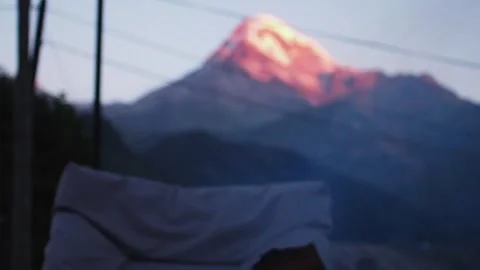 Campfire in the hearth against the backdrop of Mount Kazbegi the morning beams Stock Footage 248530858