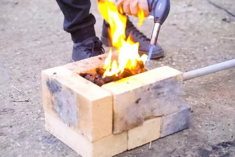 Campfire, lit between fireproof bricks for heating metal. Stock Photos