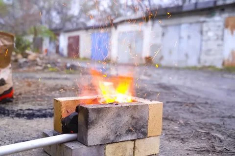 Campfire, lit between fireproof bricks for heating metal. Stock Photos
