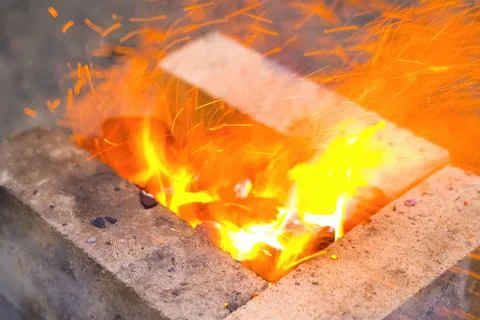 Campfire, lit between fireproof bricks for heating metal. Stock Photos