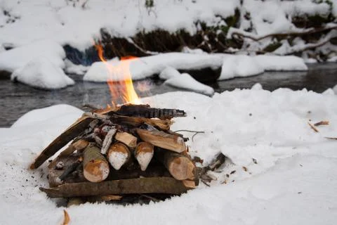 Campfire on snow in the winter forest Stock Photos