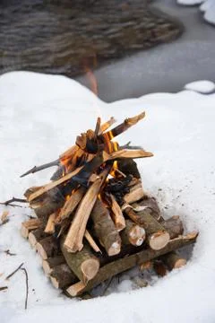 Campfire on snow in the winter forest Stock Photos