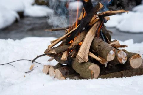 Campfire on snow in the winter forest Stock Photos