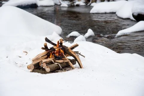 Campfire on snow in the winter forest Stock Photos