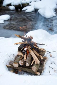 Campfire on snow in the winter forest Stock Photos