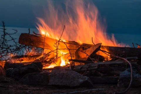 Campfire at twilight on beach Stock Photos
