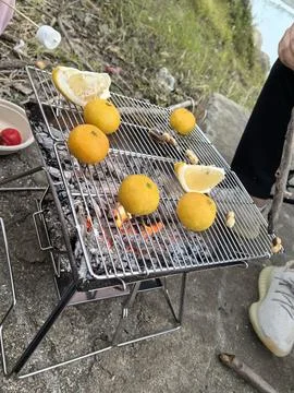 Camping Activity / Roasting Oranges over Fire Stock Photos