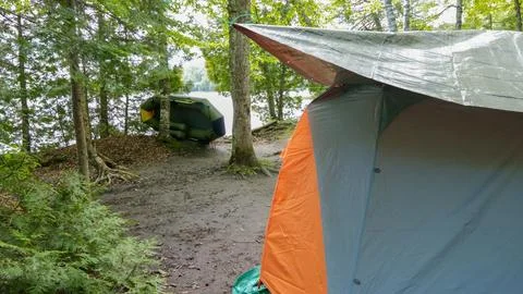 Camping and tent under the pine forest near the lake with beautiful sunligh.. Stock Photos
