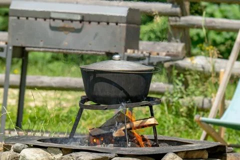 Camping bowler hat hangs over the fire Stock Photos