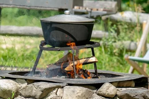 Camping bowler hat hangs over the fire Stock Photos