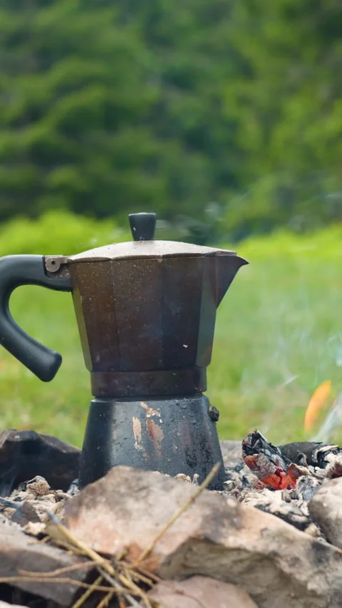 Camping coffee maker heating on campfire in mountain forest Stock Footage 335439549