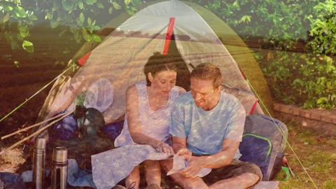 Camping couple reading map over scenic landscape and trees Stock Footage 311036479